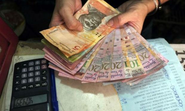 As filas ocorrem na sequência da decisão do governo do presidente Nicolás Maduro de determinar a retirada de circulação das notas de 100 bolívares (Bs), que equivalem a 0,15 euros, as de maior valor existentes no país. / Foto: AFP