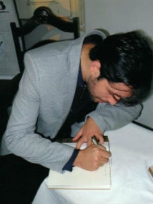 Ígor Cardoso autografando a obra de sua autoria, no IMPPE